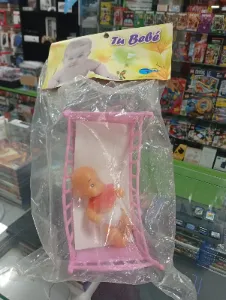 Muñeca bebé en cuna de juguete